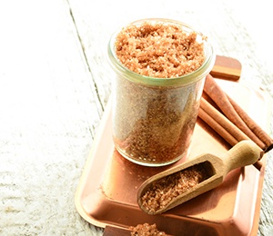 Kaffescrub som ar upphallt i en glasskal med en slev brevid med samma innehall