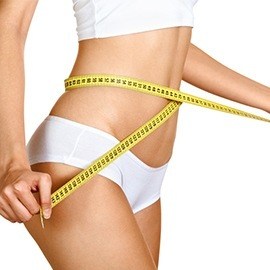 en kvinna i vita underklader mater sin midja med ett gult mattband en kvinna i vita underklader mater sin midja med ett gult mattband