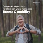 Bilden visar en leende man i en skog som bildar ett hjärta med händerna