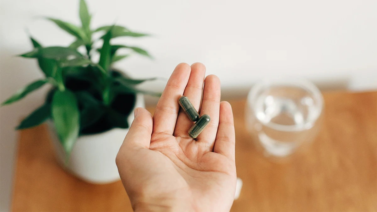 Två spirulinakapslar i hand – hur fungerar spirulina för att gå ner i vikt?